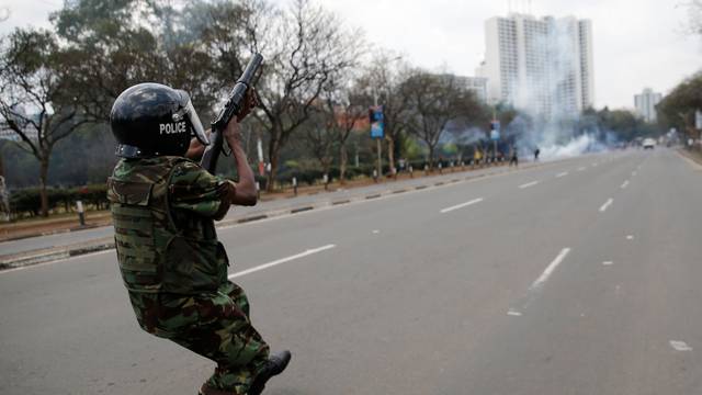 A riot policeman fires tear gas to disperse supporters of Kenyan opposition National Super Alliance coalition, during a protest along a street in Nairobi