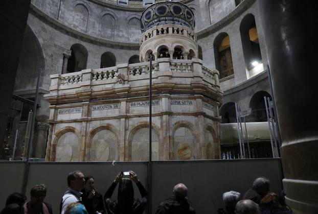 A visitor photographs the newly restored Edicule, the ancient structure housing the tomb, which according to Christian belief is where Jesus