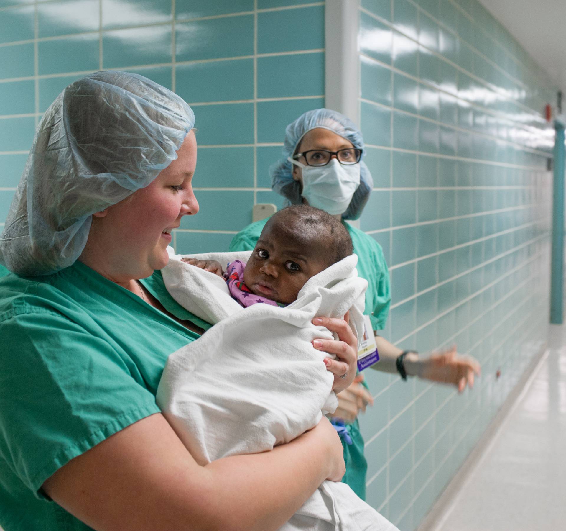 Hospital staff carry 10-month old "Baby Dominique" into surgery to treat the infant born with four legs and two spines at Advocate Children's Hospital in Park Ridge, Illinois