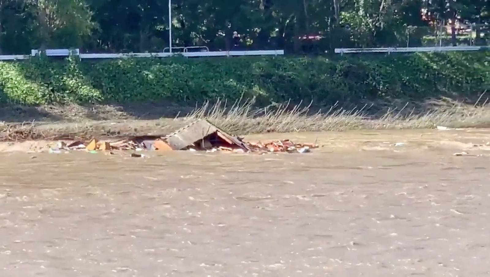 The roof of a collapsed house floats down a river in the aftermath of Typhoon Hagibis in Saku City