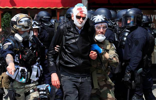 An injured protester is evacuated by street medics after clashes before the start of the traditional May Day labour union march in Paris