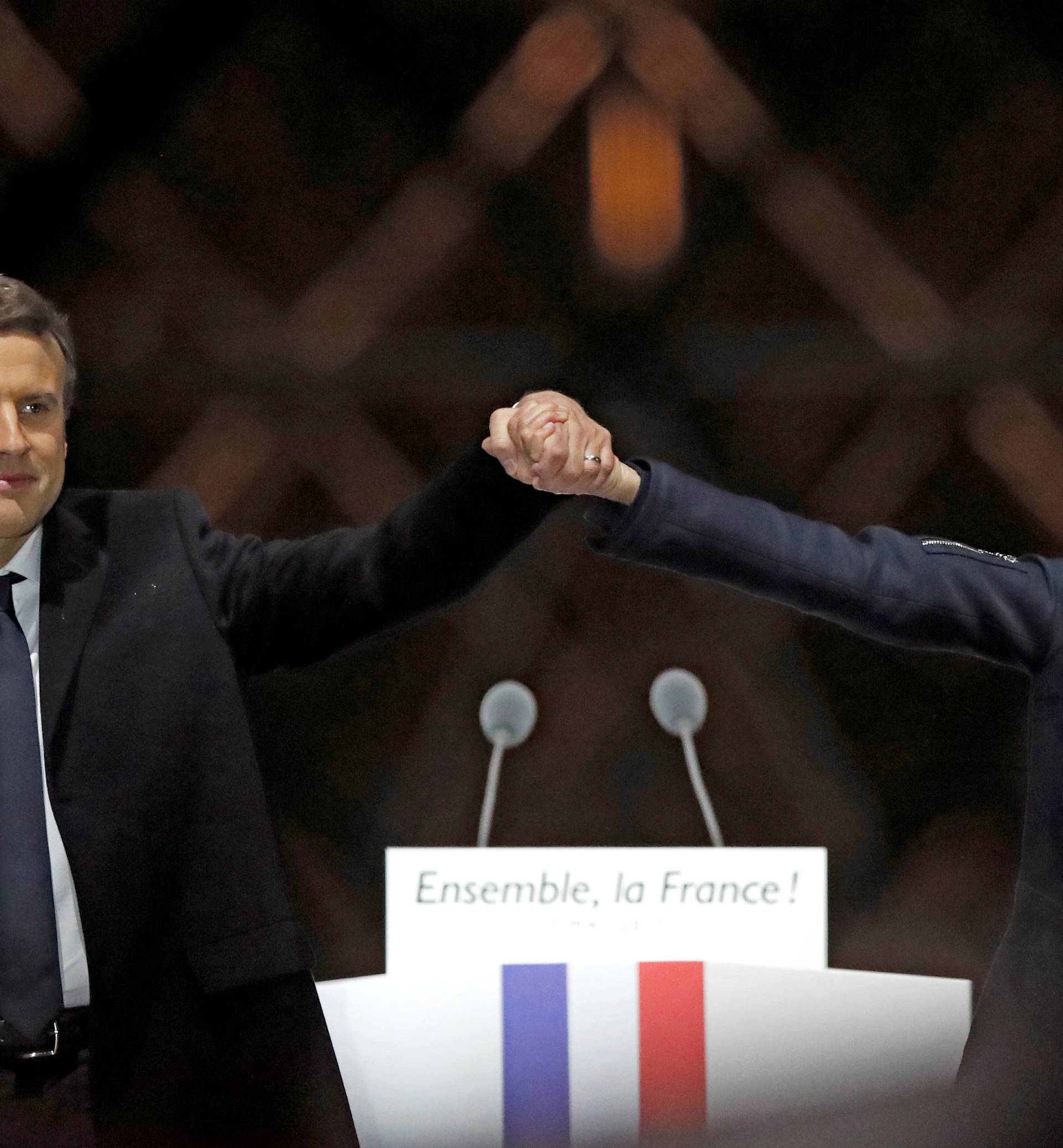 French President elect Emmanuel Macron and his wife Brigitte Trogneux celebrate on the stage at his victory rally near the Louvre in Paris