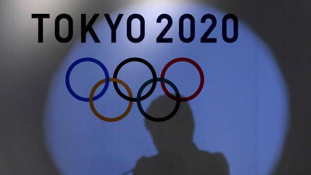 FILE PHOTO: Shadow of of Tokyo governor Yuriko Koike is seen on the logo of Tokyo 2020 Olympic games during the Olympic and Paralympic flag-raising ceremony at Tokyo Metropolitan Government Building in Tokyo