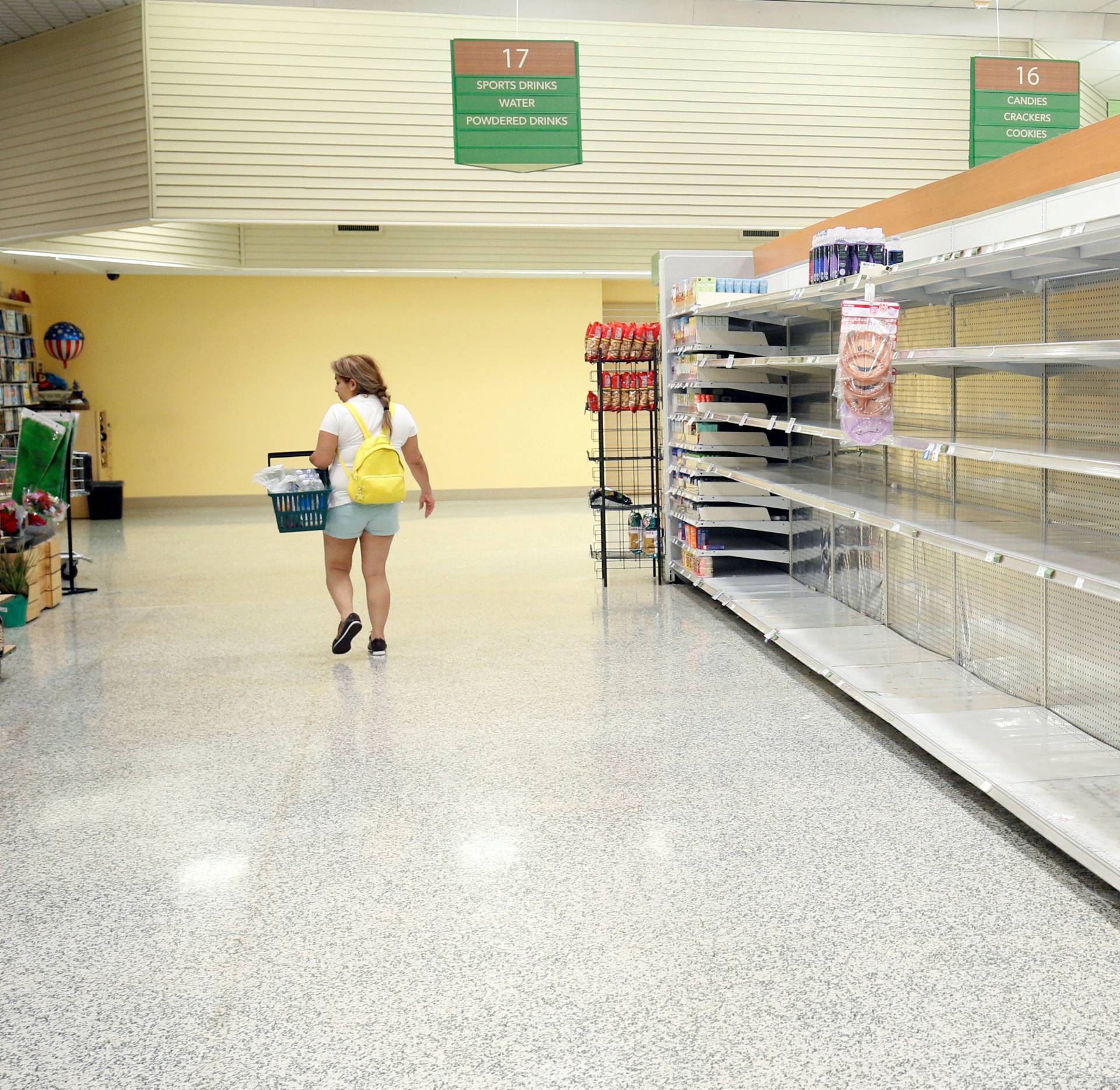 A shopper walks past empty shelves at a supermarket ahead of Hurricane Irma making landfall in Kissimmee