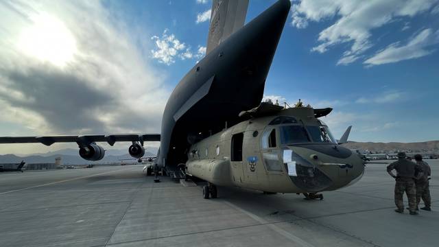 A CH-47 Chinook is loaded onto a U.S. Air Force C-17 Globemaster III at Hamid Karzai International Airport in Kabul