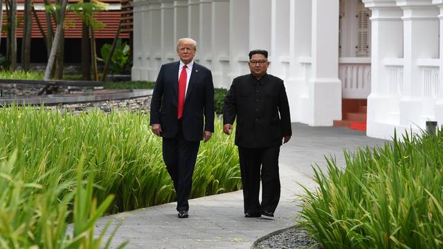 U.S. President Donald Trump and North Korean leader Kim Jong Un walk in the Capella Hotel after their working lunch, on Sentosa island in Singapore