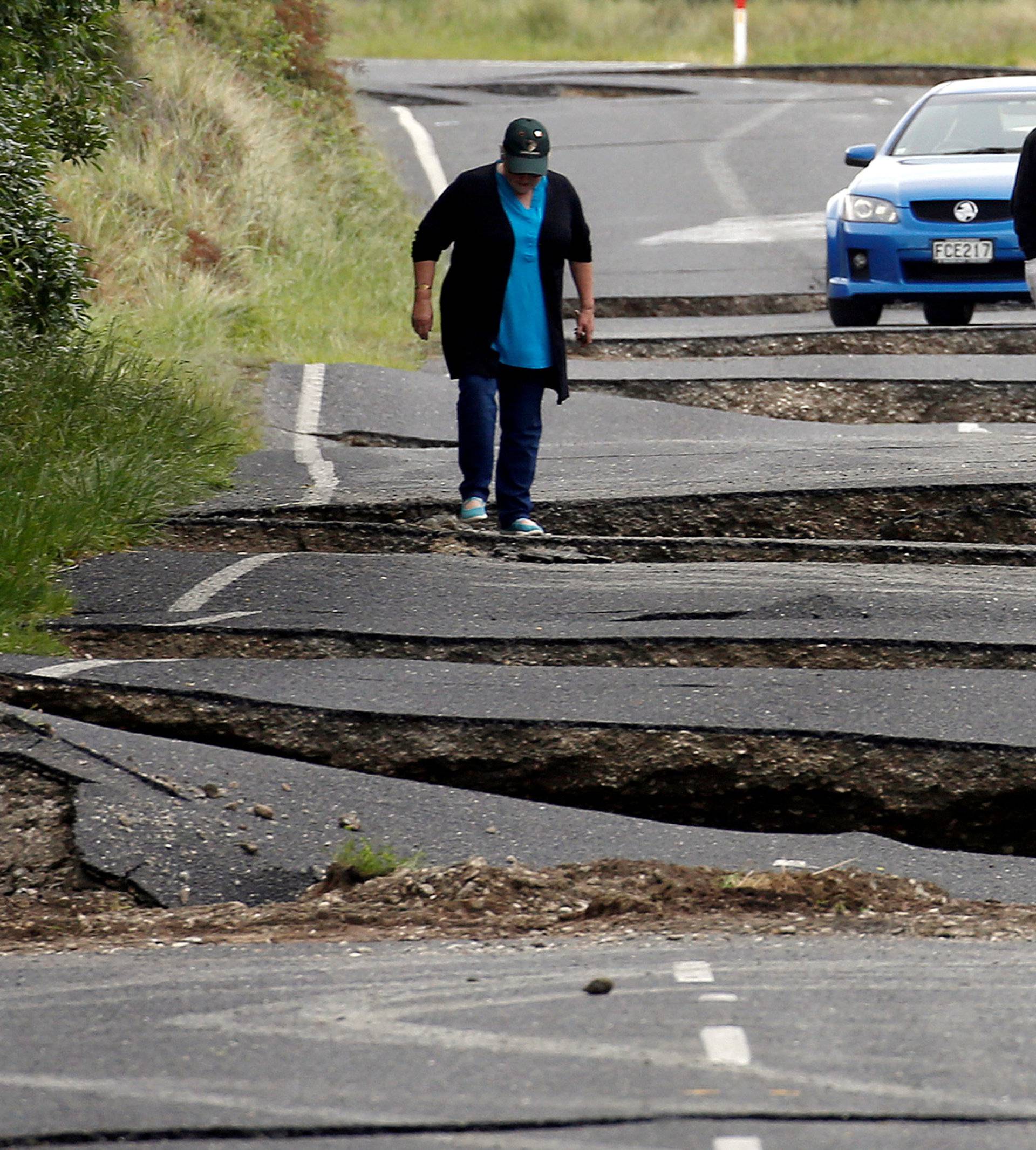 Local residents Chris and Viv Young look at damage caused by an earthquake, along State Highway One near the town of Ward, New Zealand