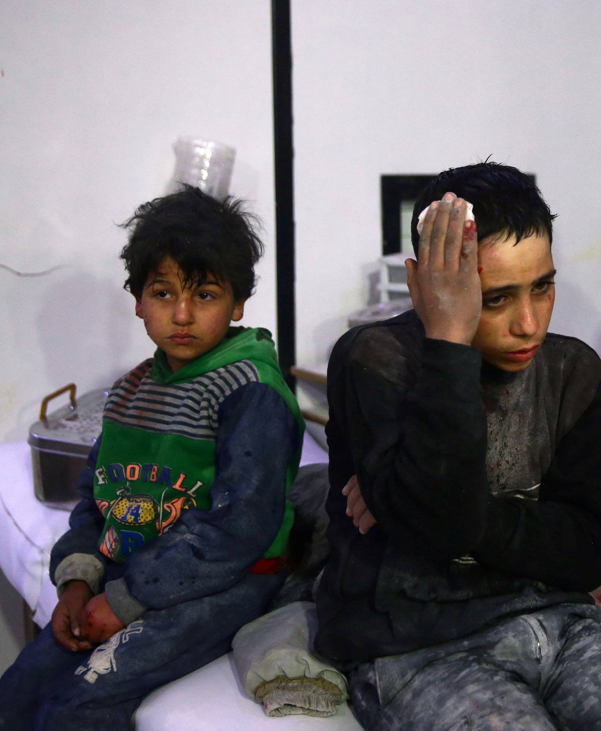Wounded children and man are seen in a hospital in the besieged town of Douma, Eastern Ghouta