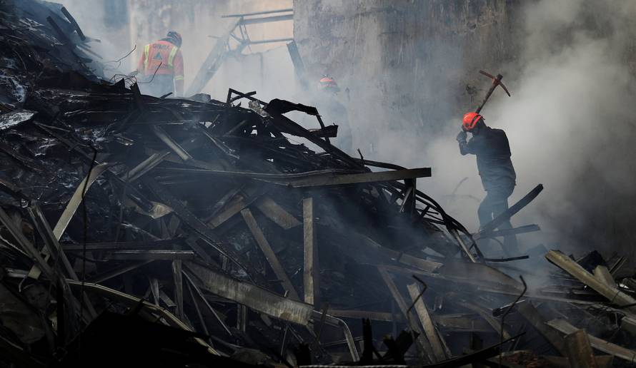 Firefighters try to extinguish a fire of a building that caught fire and collapsed in the center of Sao Paulo
