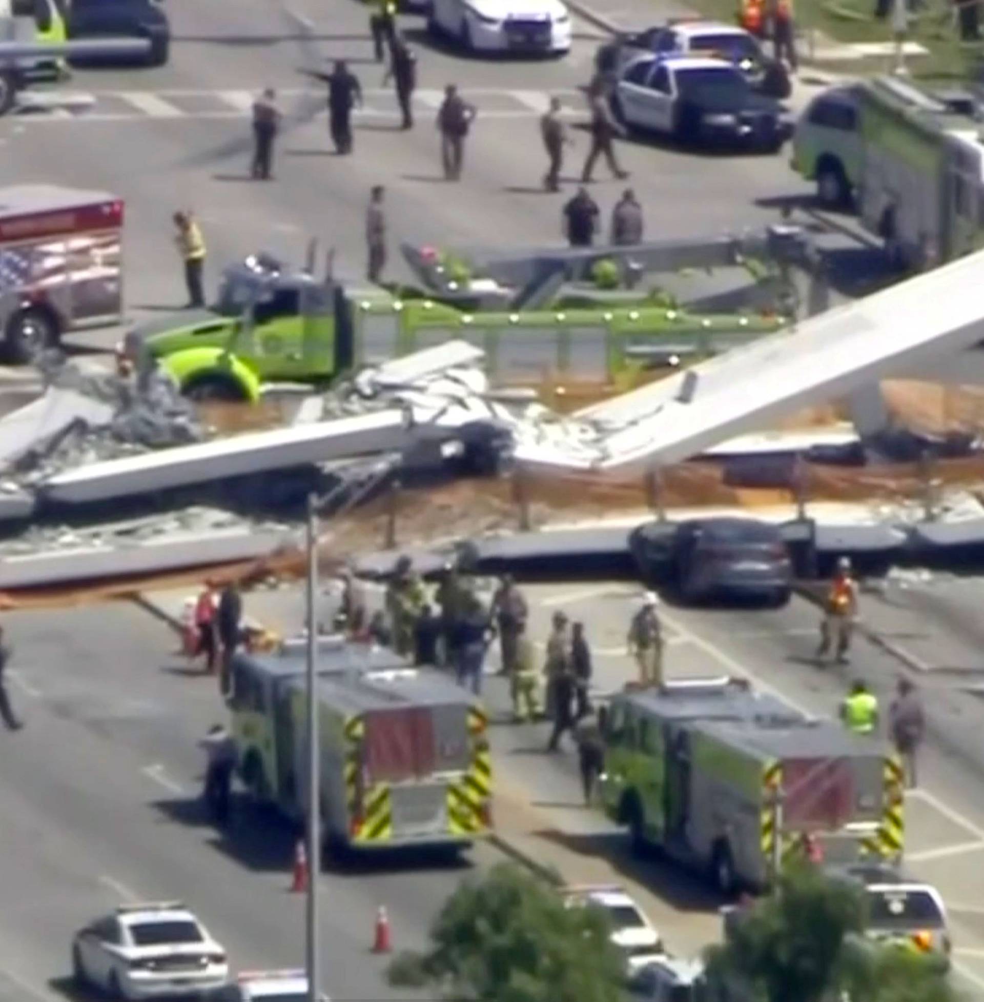 Emergency crews look for victims at the scene of a collapsed pedestrian bridge at Florida International University in Miami, Florida