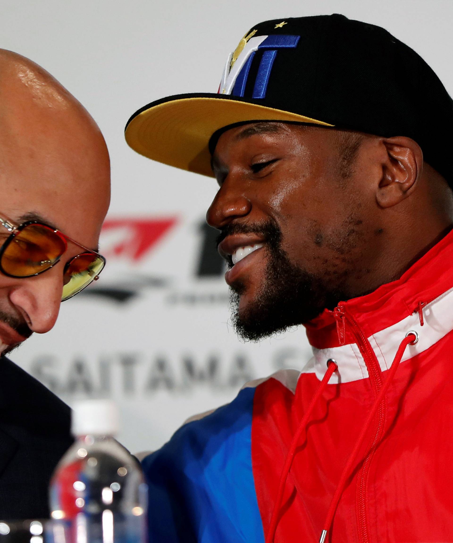 Boxer Floyd Mayweather Jr. of the U.S. talks with Brent Johnson from One Entertainment during a news conference in Tokyo