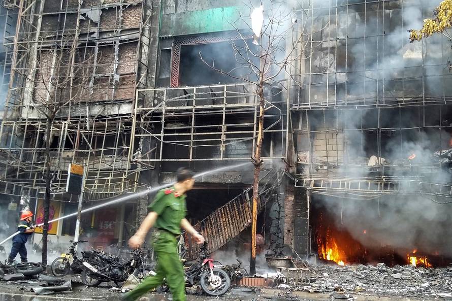 Firefighters work after a fire broke out at a karaoke lounge in Hanoi
