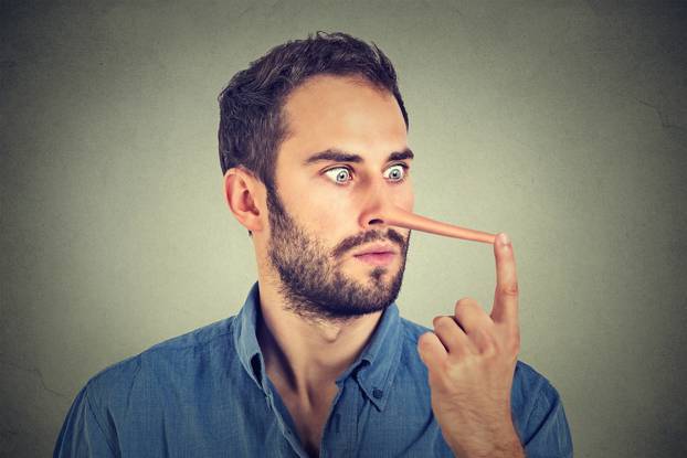 Man with long nose isolated on grey wall background. Liar concep