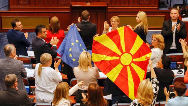 North Macedonia's SDSM party members of Parliament hold EU and Macedonian flags during debate on a French-brokered deal, in Skopje