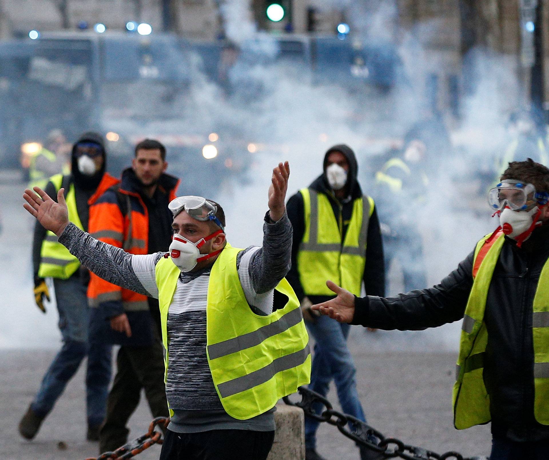 Protesters wearing yellow vests, a symbol of a French drivers' protest against higher diesel taxes, face off with French gendarmes during clashes at the Place de l'Etoile in Paris