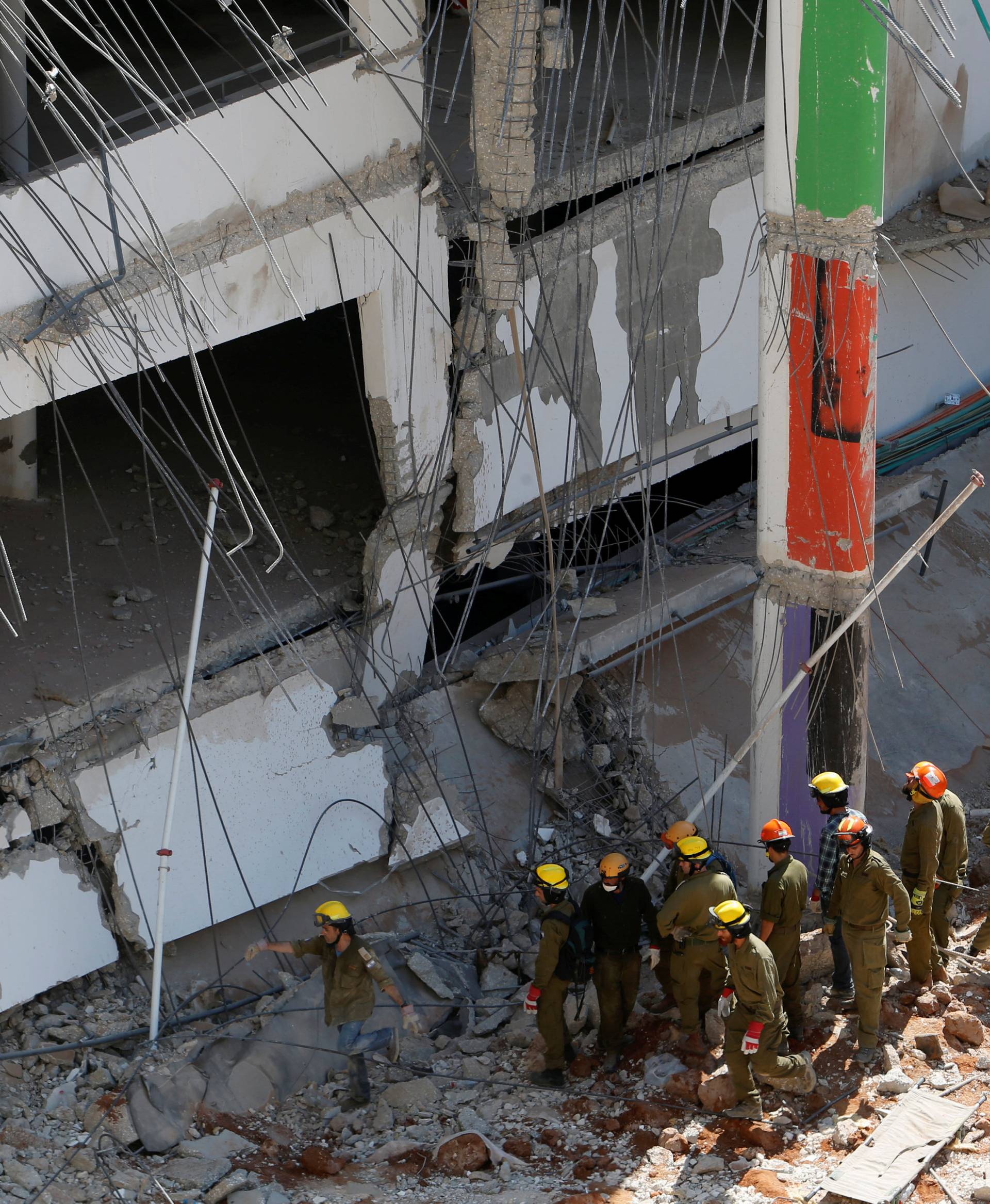 Israeli rescue services search through the rubble after a building site collapsed in Tel Aviv