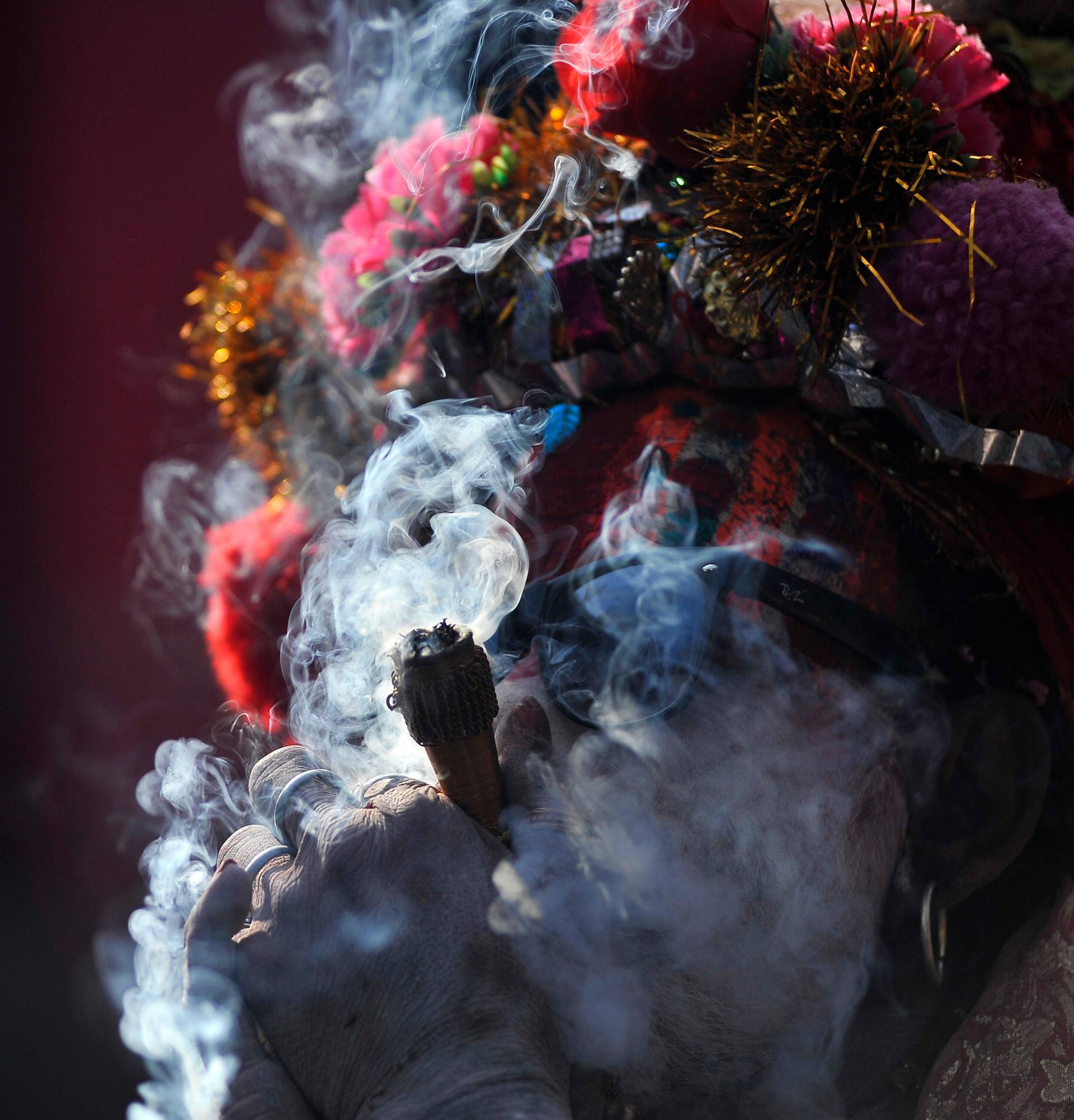 Kathmandu, Nepal. 24th Feb, 2017. A colorful Hindu Sadhu or Holy Man smokes marijuana at the premises of Pashupatinath Temple during the celebration of Maha Shivaratri Festival at Kathmandu, Nepal on Friday, February 24, 2017. Thousands of Hindu Sadhu or 