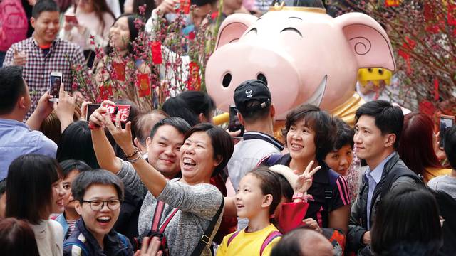 Visitors take pictures of an installation at a flower fair ahead of the Chinese Lunar New Year of the Pig, in Guangzhou