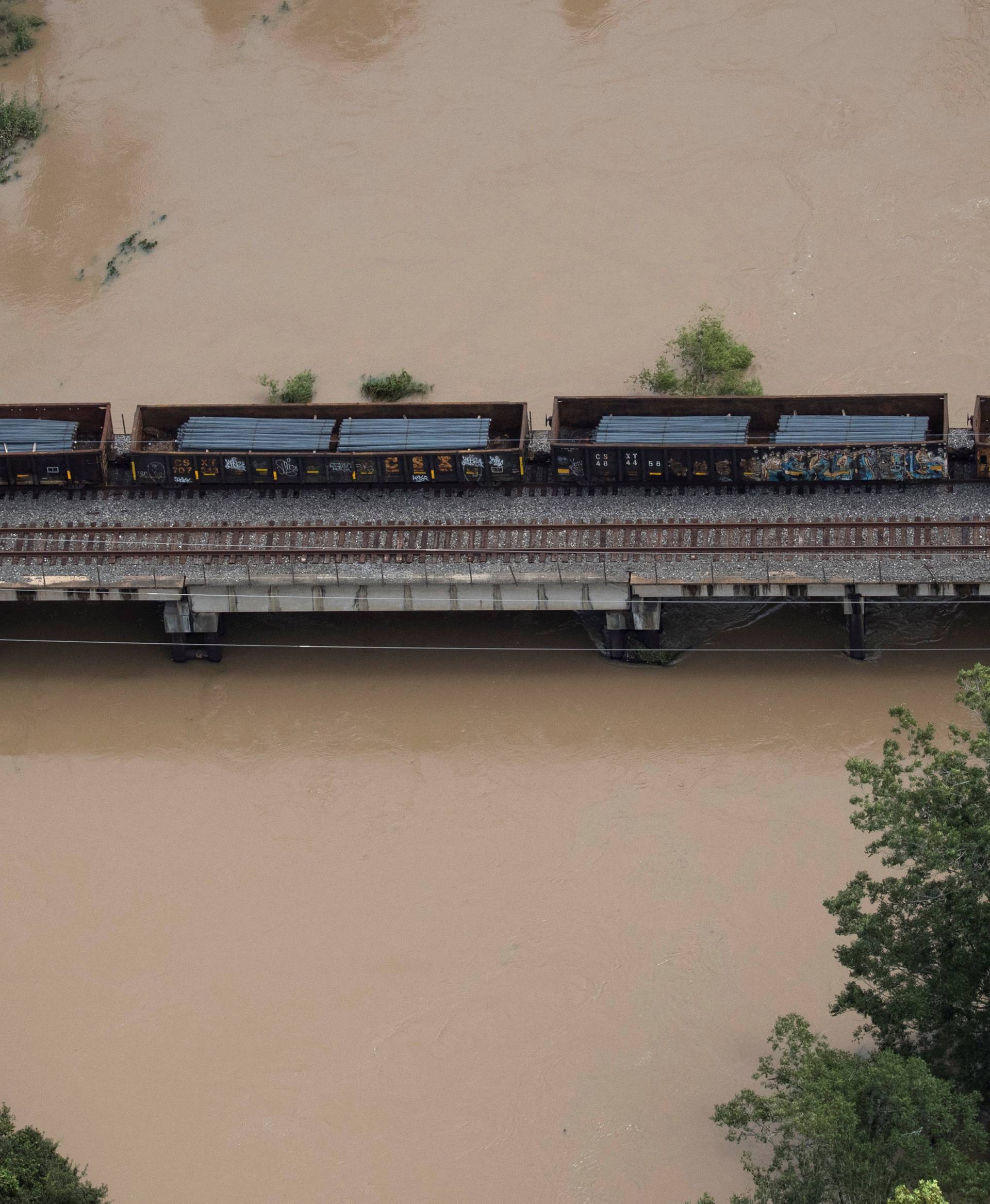 A rail line with cars are seen atop Buffalo Bayou flooded by Tropical Storm Harvey in Houston