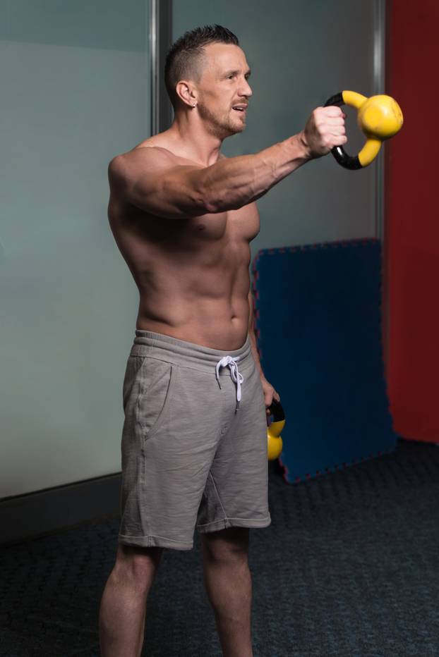 Young Man Exercising With Kettle Bell