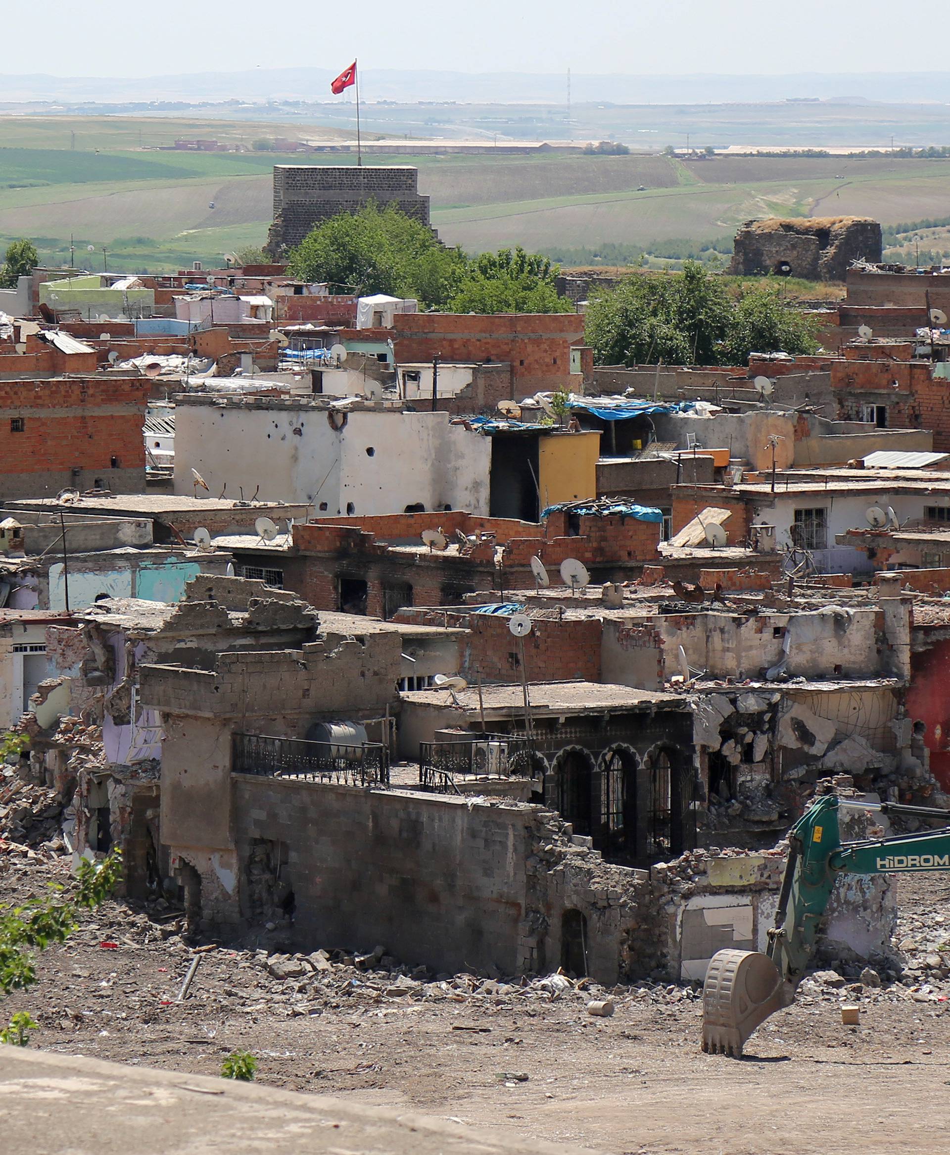 An excavator is seen next to buildings which were damaged during security operations and clashes between Turkish security forces and Kurdish militants, in Sur district of Diyarbakir