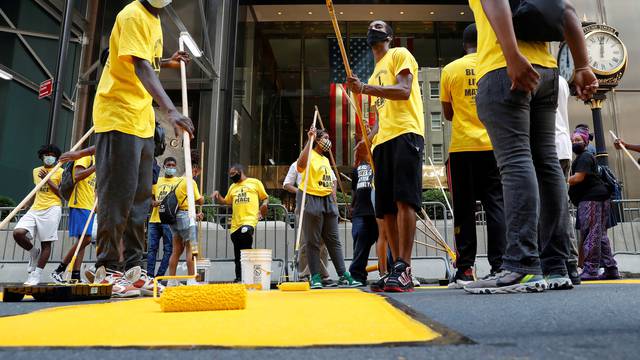 People paint a "Black Lives Matter" along 5th avenue outside Trump Tower in New York City