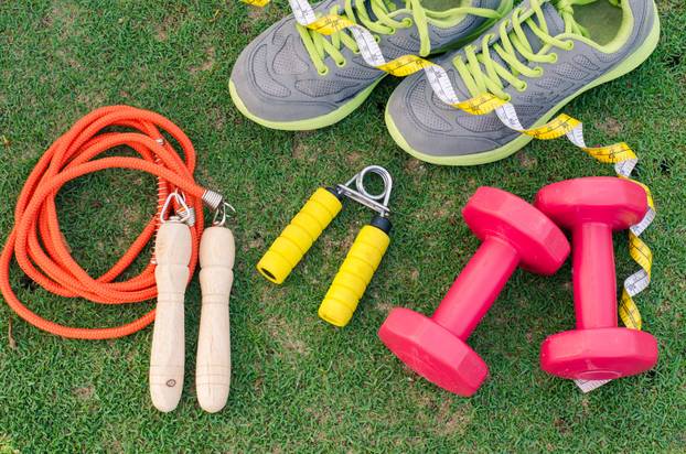 fitness concept with Exercise Equipment on green grass backgroun