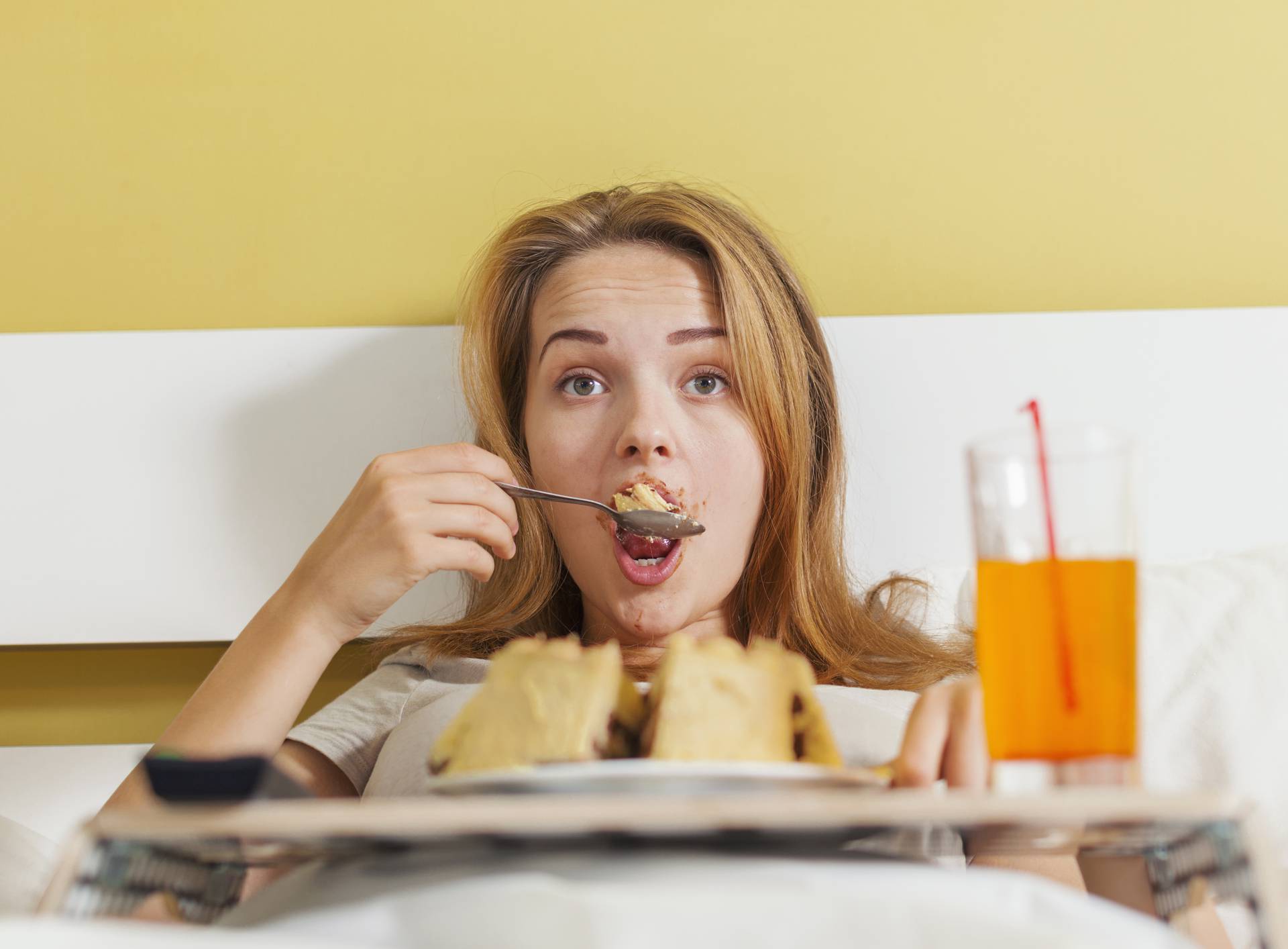 Day gluttony, teen girl eating a cake and drinks soda