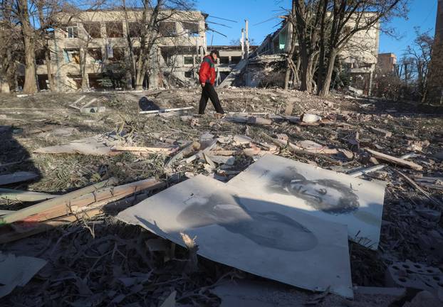 A resident walks near a school building destroyed during Russian air strikes in the town of Sloviansk