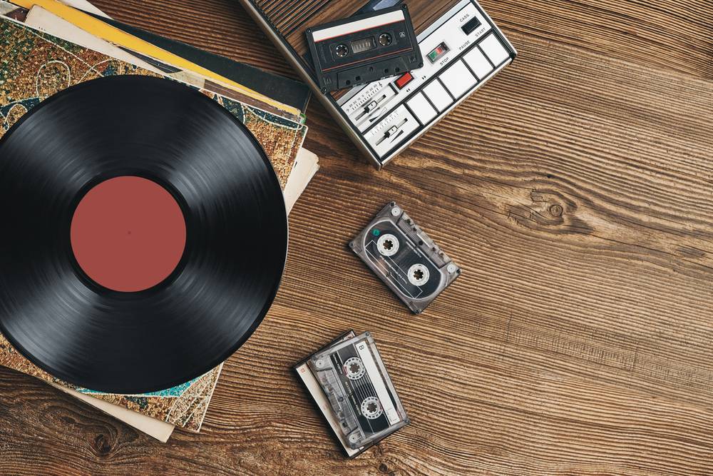 Vinyl,Records,,Cassette,Tapes,And,Cassette,Recorder,On,Wooden,Table.