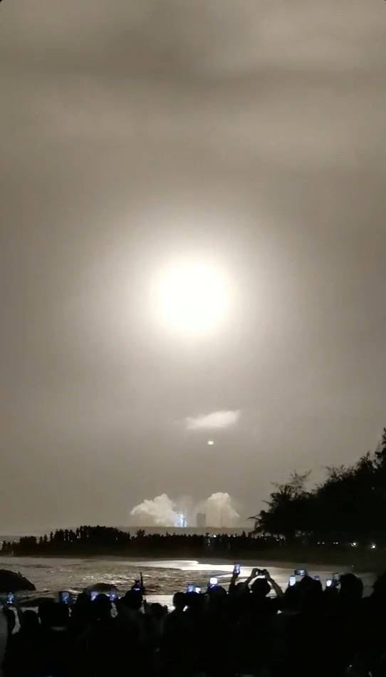 Social media video grab of people watching the Long March-5, China's largest carrier rocket carrying the Chang'e-5 spacecraft, blasting off in a launch from Wenchang Space Launch Center in Hainan