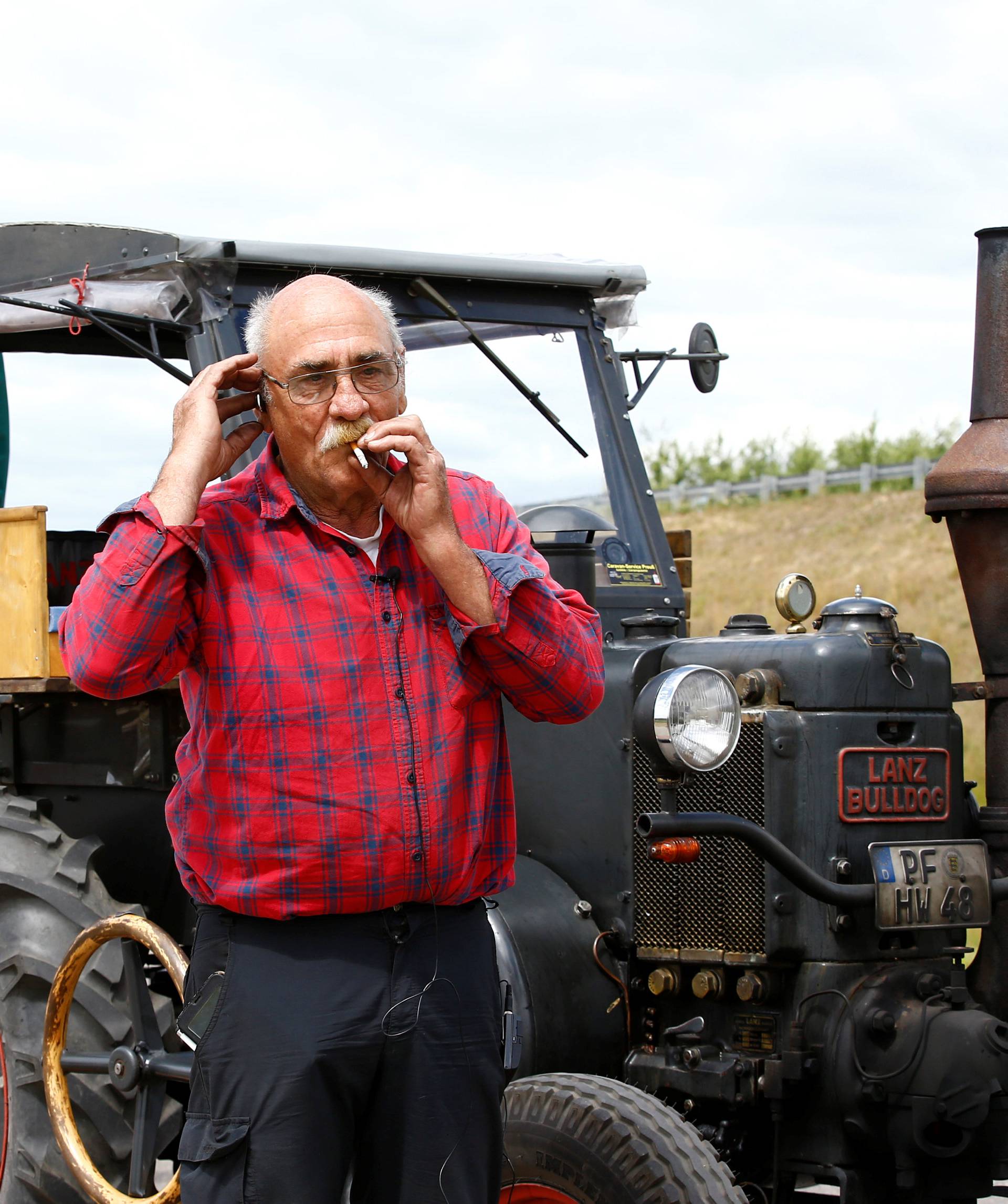 Soccer fan from Pforzheim, Germany, Hubert Wirth, 70, speaks on the phone while he rests by his tractor during his travel to attend the FIFA 2018 World Cup in Russia near the village of Yasen