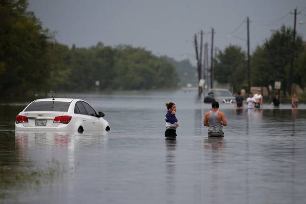Residents wade through flood waters from Tropical Storm Harvey in Houston, Texas