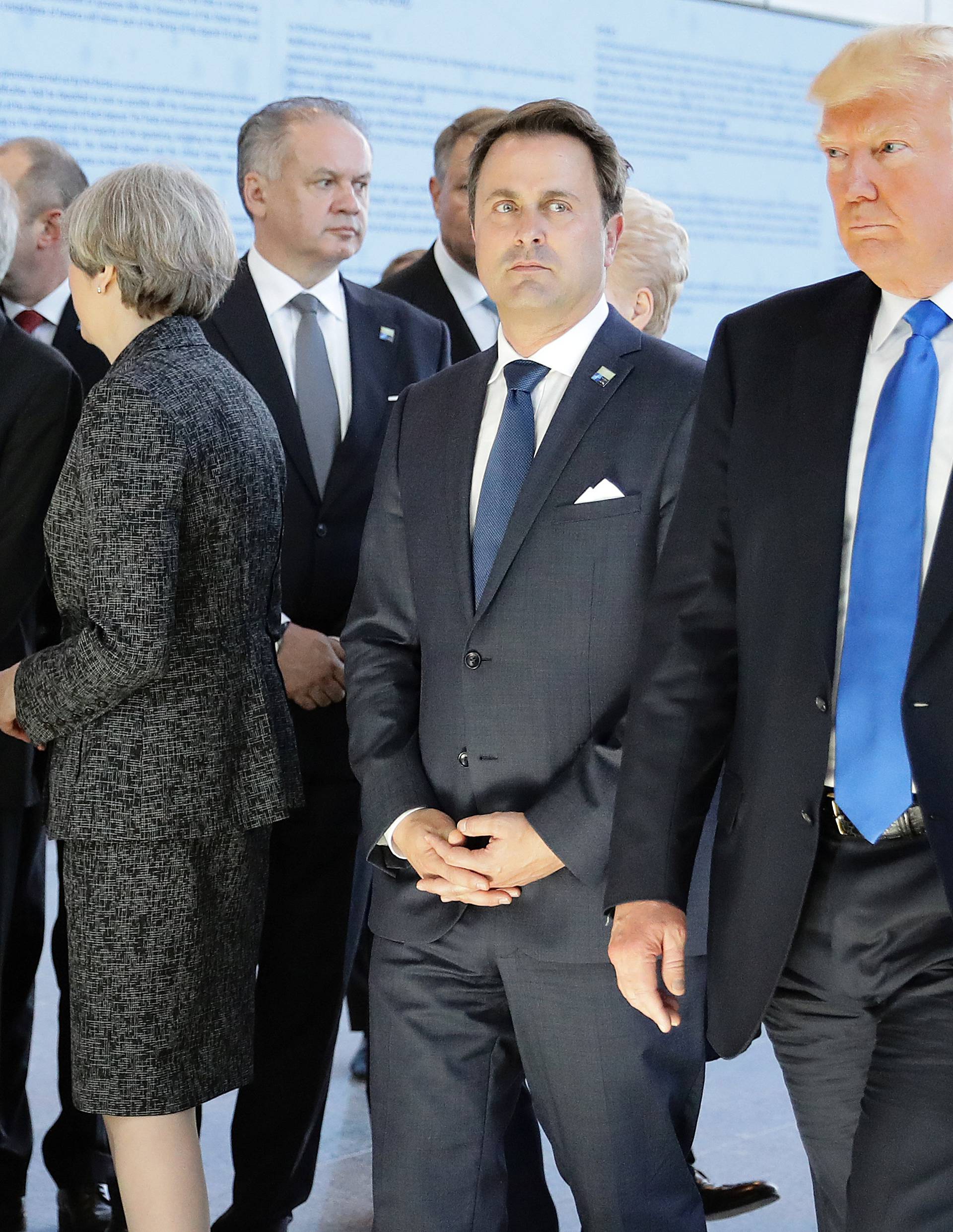 U.S. President Donald Trump and Luxembourg's Prime Minister Xavier Bettel walk past Britain's Prime Minster Theresa May before the start of the NATO summit at their new headquarters in Brussels