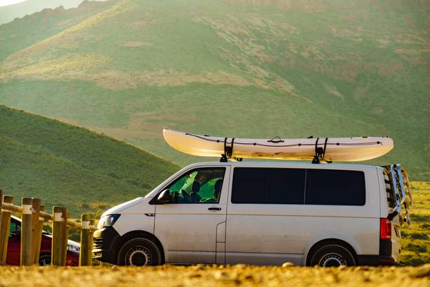 Car,Van,With,Canoe,On,Top,Roof,Against,Mountain,Nature.