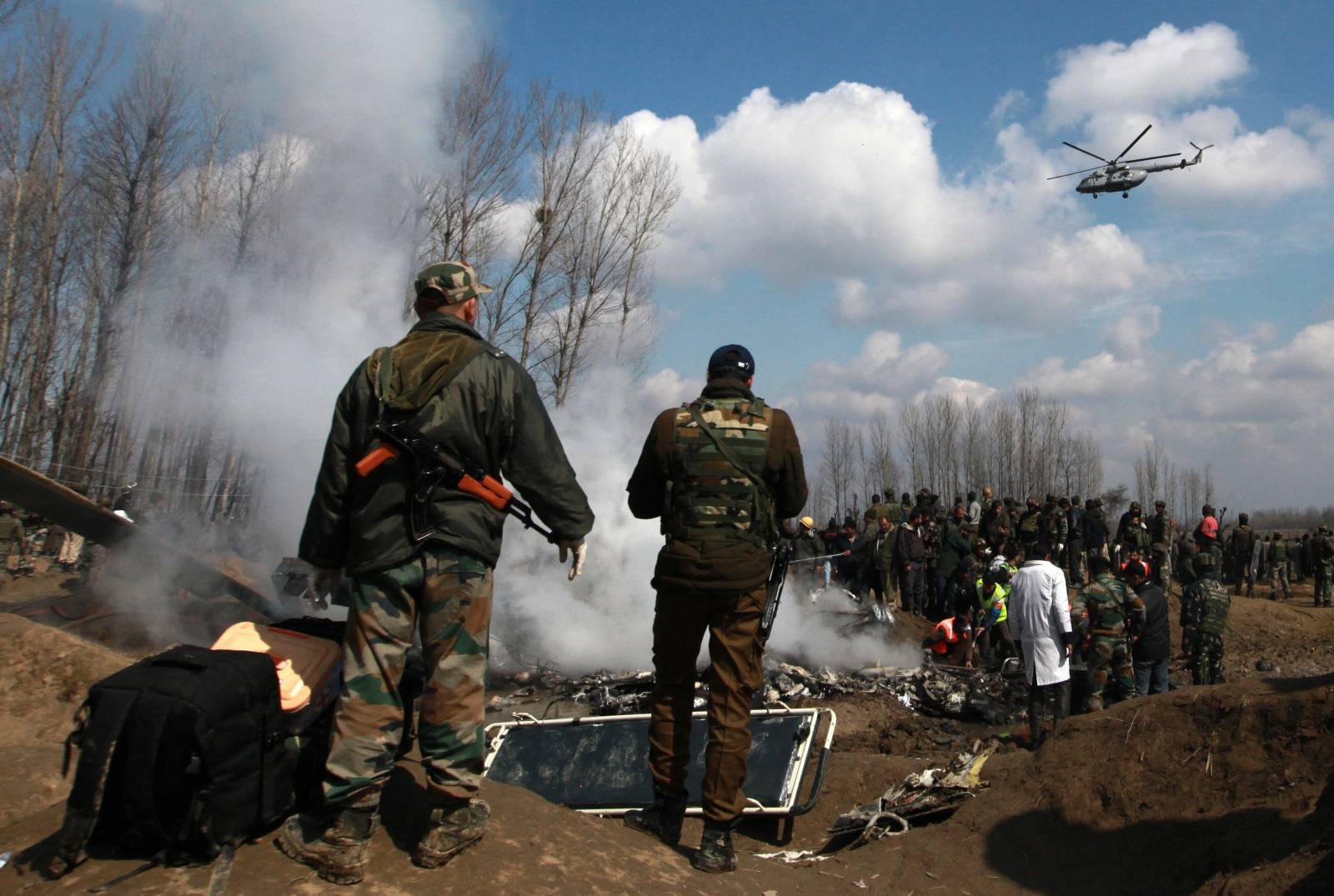 Indian soldiers stand next to the wreckage of Indian Air Force's helicopter after it crashed in Budgam