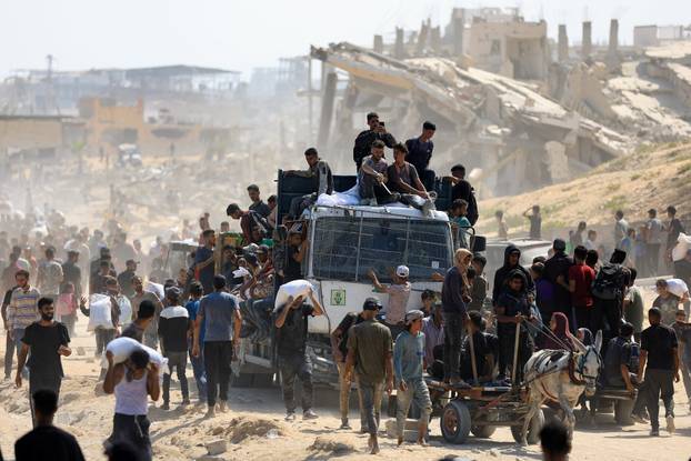 Palestinians gather to receive aid supplies amid a hunger crisis, in Beit Lahia