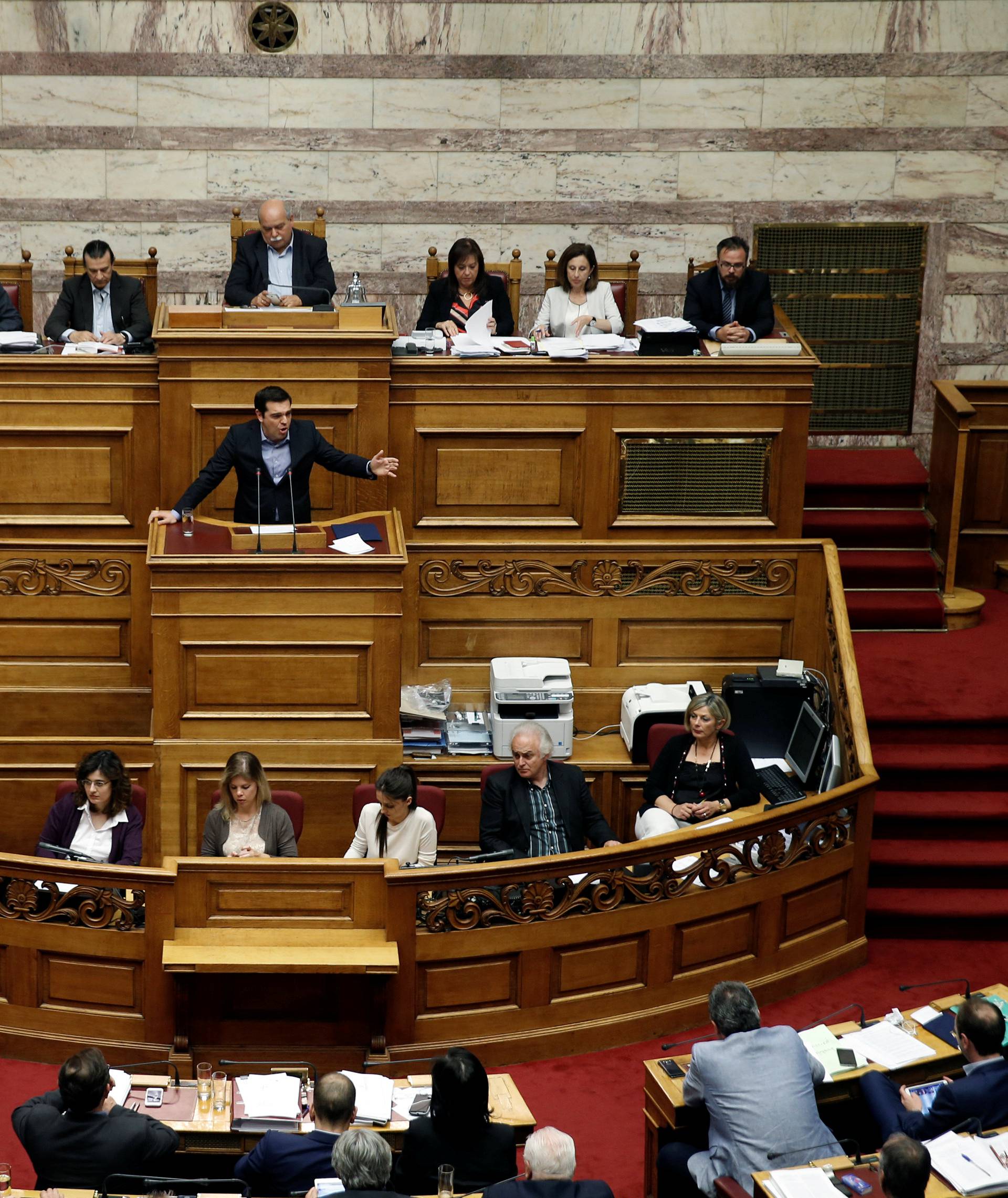 Greek PM Tsipras addresses lawmakers during a parliamentary session before a vote of tax and pension reforms in Athens