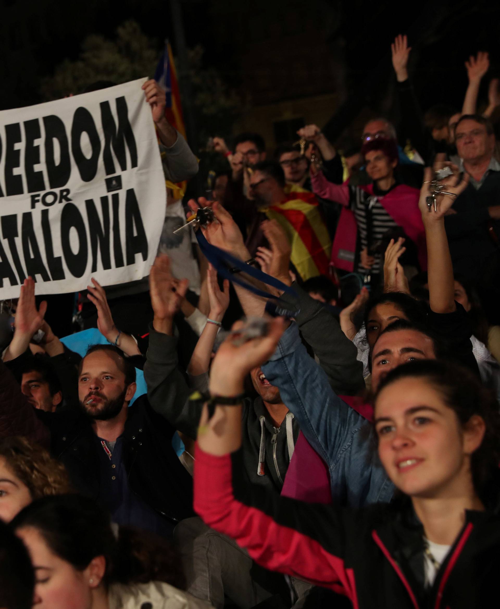 People react as they gather at Plaza Catalunya after voting ended for the banned independence referendum, in Barcelona