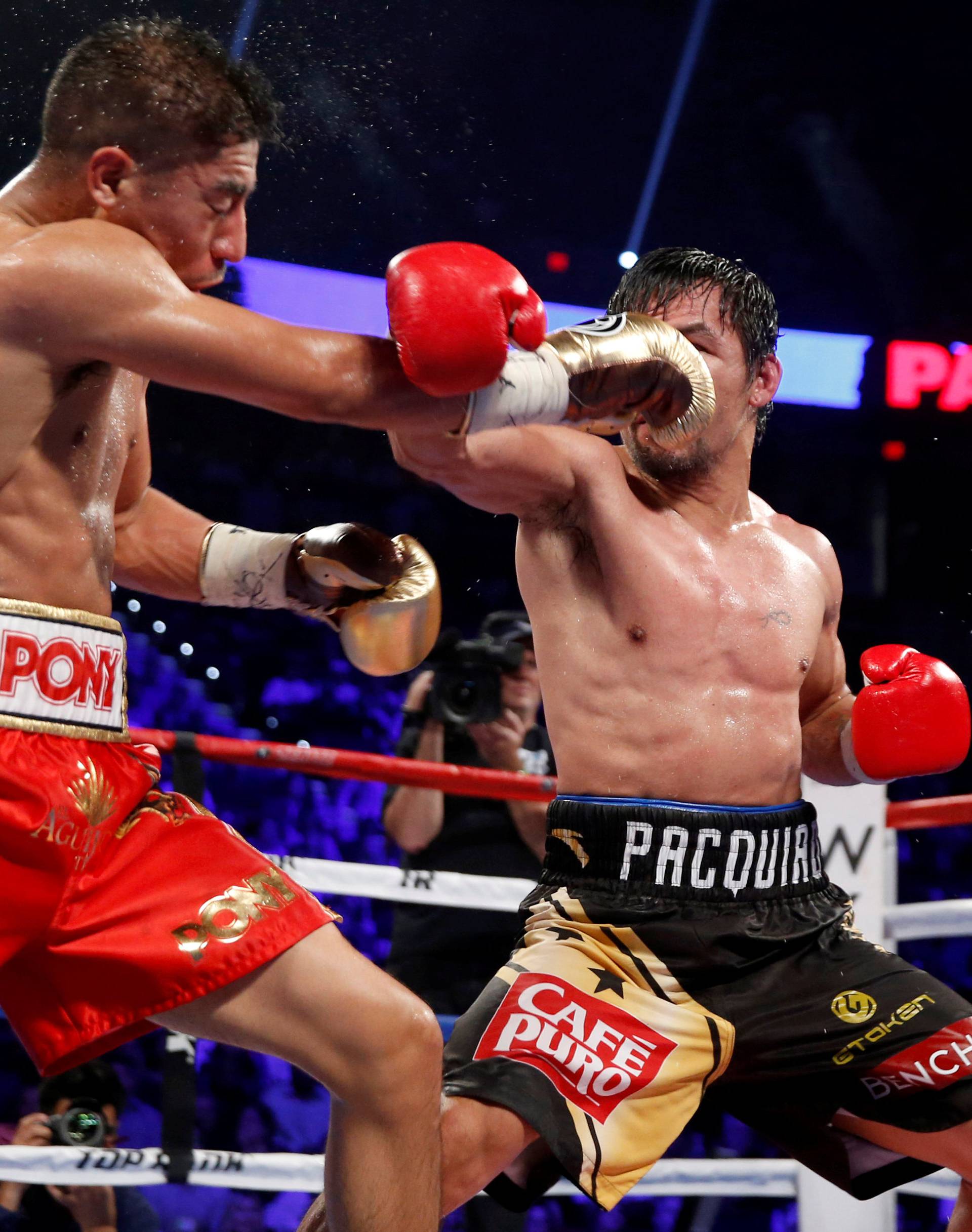 WBO welterweight champion Jessie Vargas (L) of Las Vegas takes a punch from Manny Pacquiao of the Philippines during their title fight at the Thomas & Mack Center in Las Vegas