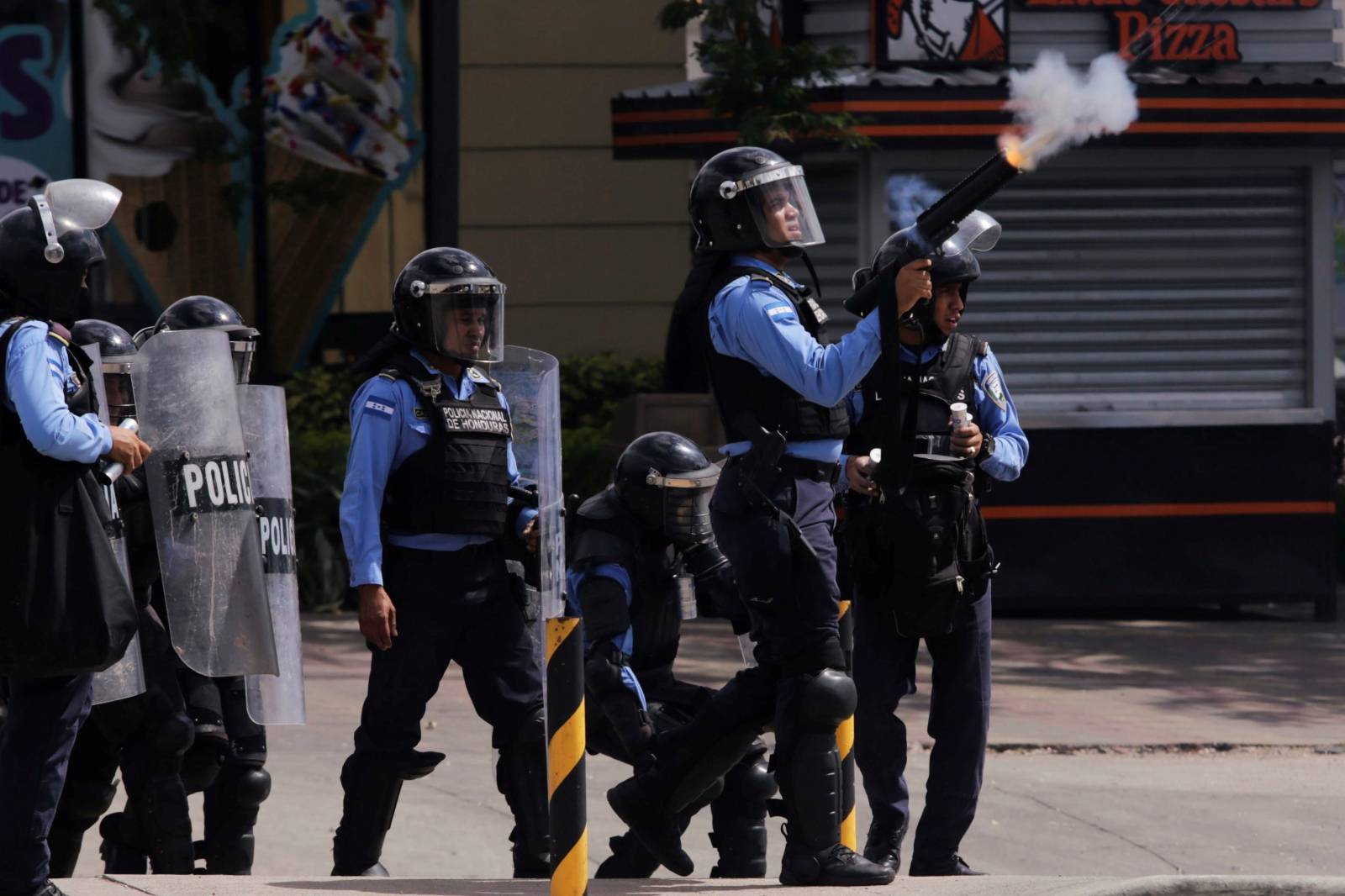 Police officers fire a tear gas canister towards demonstrators during a protest against the government of Honduran President Juan Orlando Hernandez in Tegucigalpa