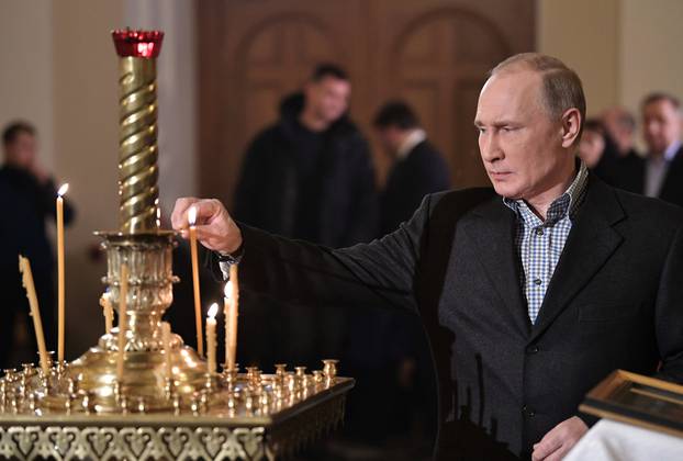 Russian President Vladimir Putin attends a service on Orthodox Christmas at the Church of Saints Simeon and Anna in St. Petersburg