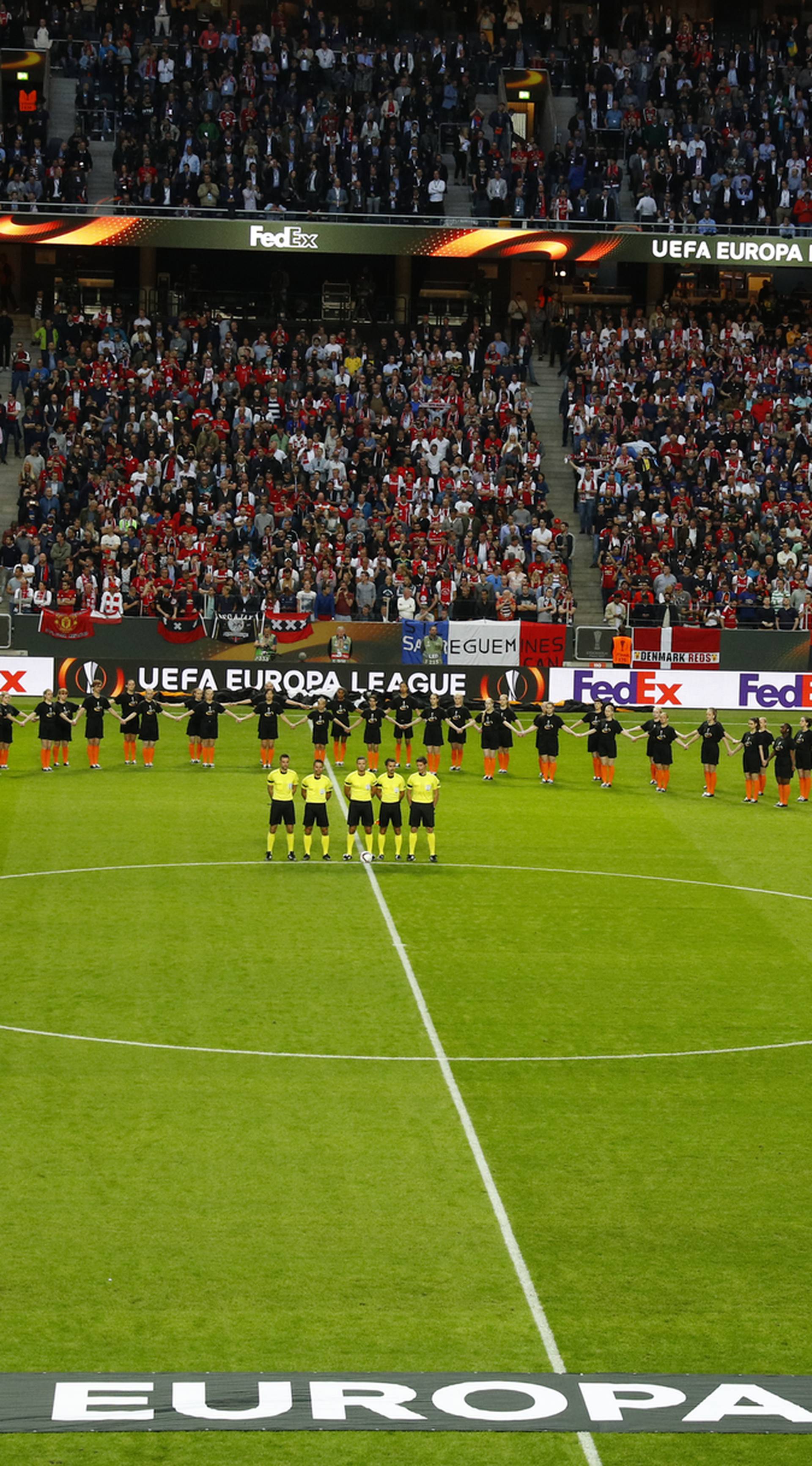 Players, officials and fans observe a minute of silence in tribute to the victims of the Manchester attack