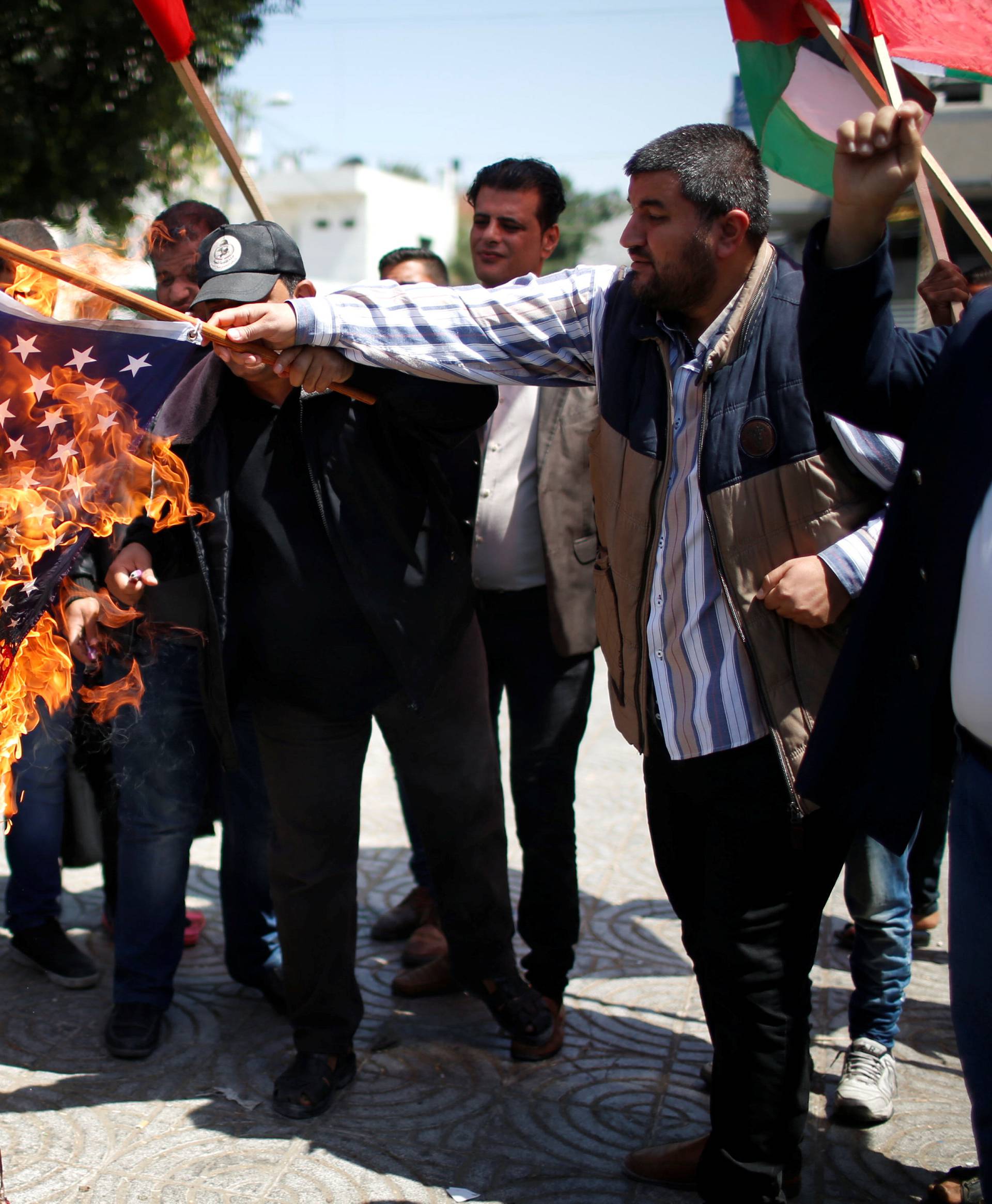 Palestinians burn a U.S flag during a protest against U.S.-led air strikes in Damascus, in Gaza city