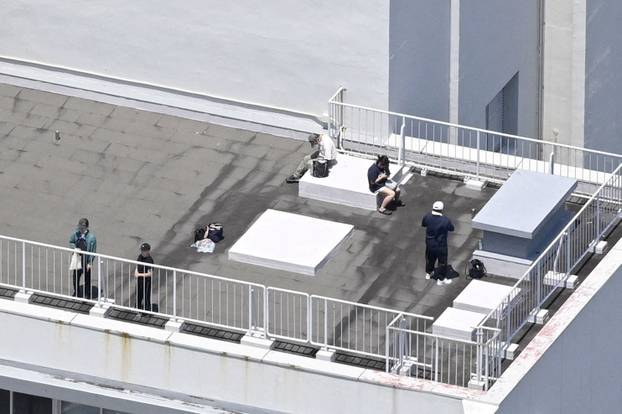 Photo taken from a Kyodo News helicopter shows people who evacuated to the rooftop of a building in Kushimoto, after the Japan Meteorological Agency issued a tsunami warning.