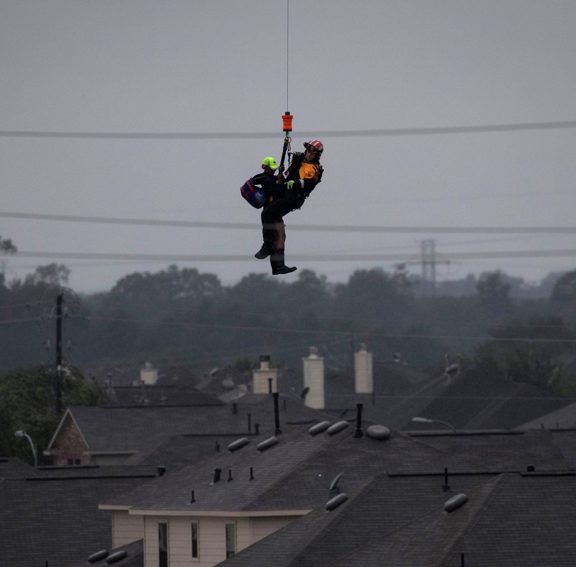 Military helicopter and personnel rescue stranded resident from floods caused by Tropical Storm Harvey in Houston