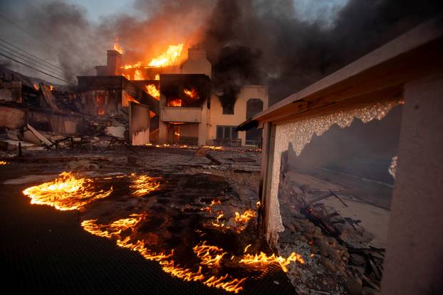 Palisades fire burns during a windstorm on the west side of Los Angeles