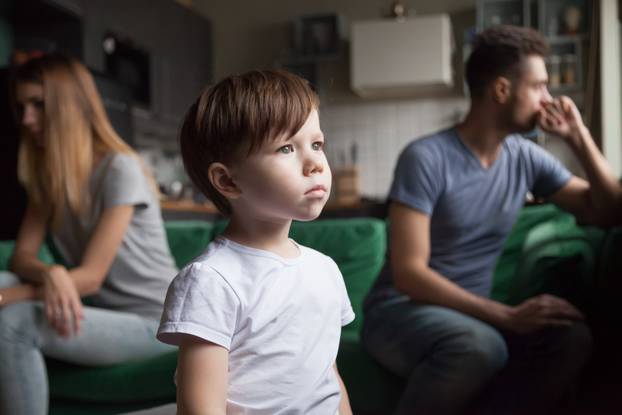 Upset, frustrated little boy tired of parents fight