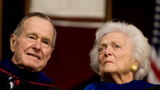 FILE PHOTO - Former President George H.W. Bush, and former first lady, Barbara Bush, attend the Texas A&M University commencement ceremony in College Station