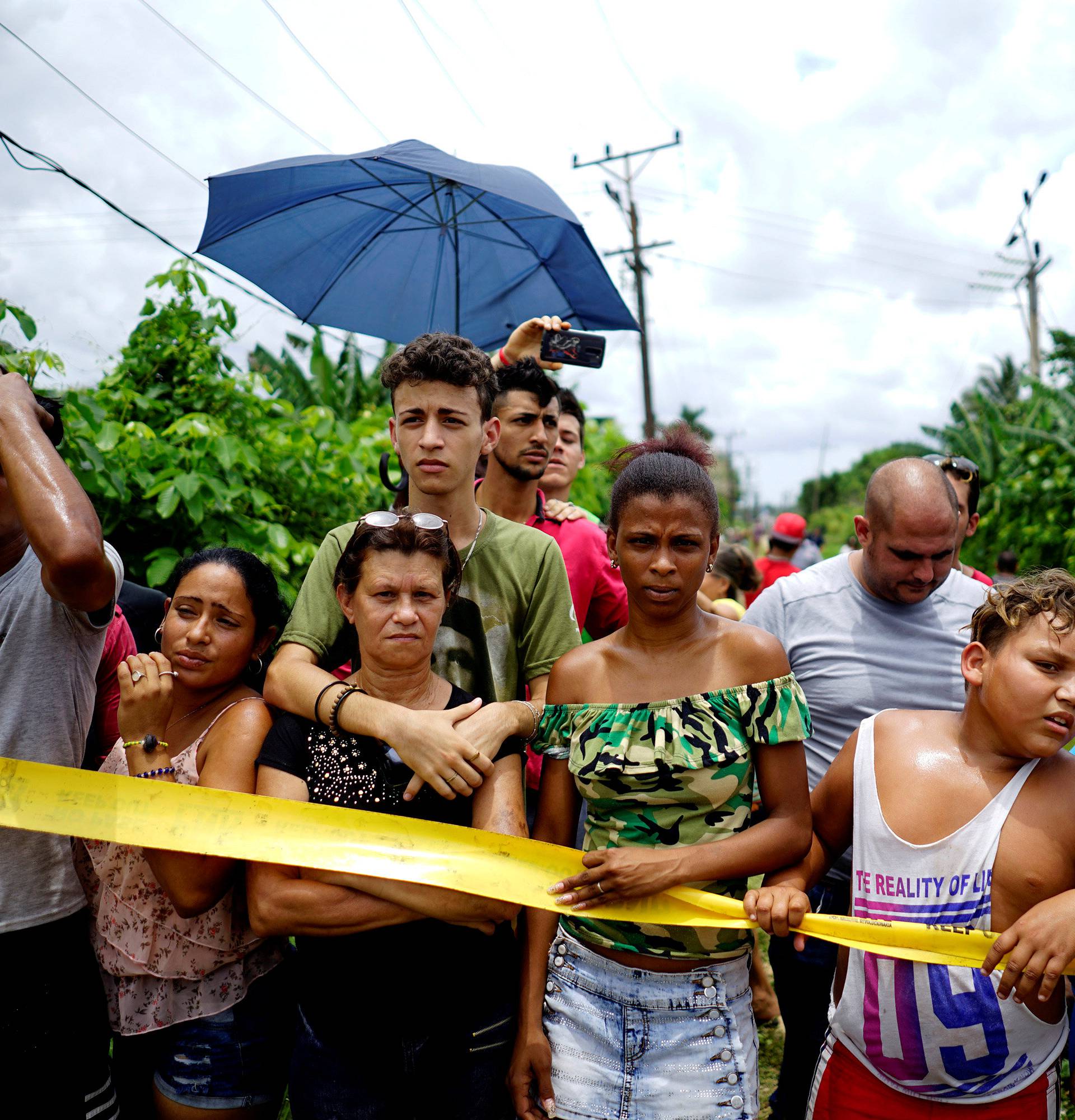 People look on near of the wreckage of a Boeing 737 plane that crashed in the agricultural area in Boyeros,